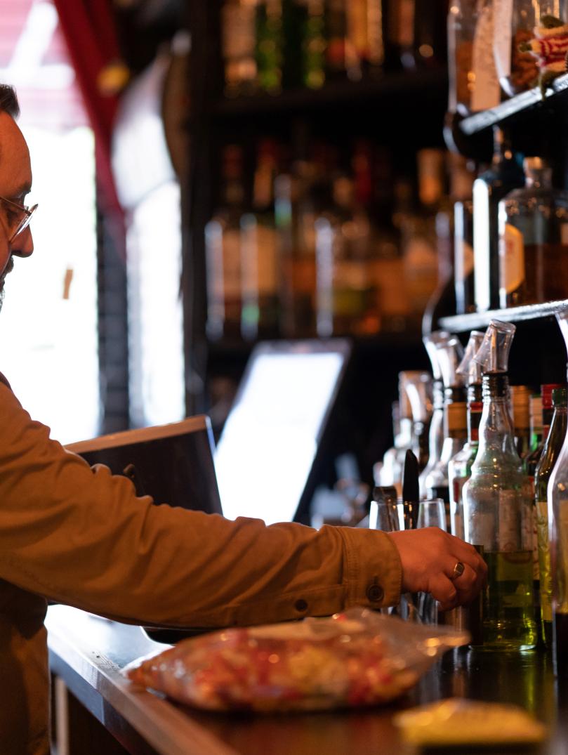Dan with beard and glasses works behind the bar of porters
